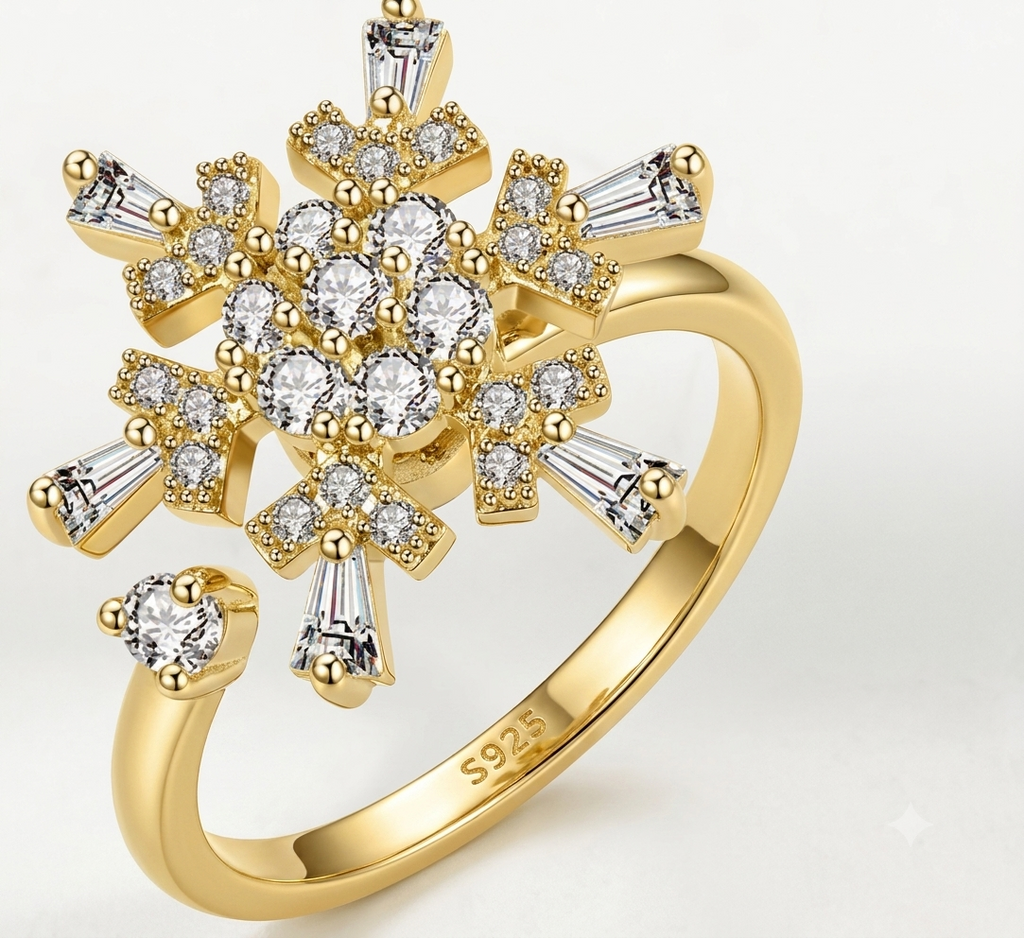 Detailed close-up of S925 gold and silver rotating snowflake rings on a neutral textured background